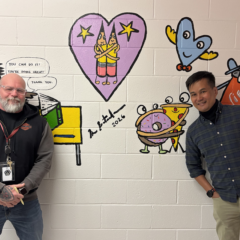 Harrington Elementary School Principal Rob Asselin, left, poses with artist Bren Bataclan in front of the freshly completed hallway mural on Friday, March 20, 2026.