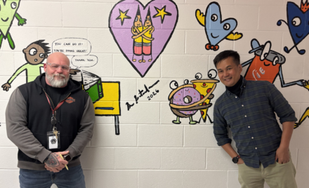 Harrington Elementary School Principal Rob Asselin, left, poses with artist Bren Bataclan in front of the freshly completed hallway mural on Friday, March 20, 2026.