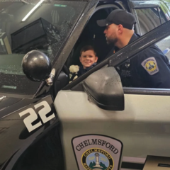 Chelmsford Police Officer Cory D'Entremont shows 6-year-old Tyler Bolger around the inside of a police cruiser during Tyler's visit to the police station with his family. Cops for Kids with Cancer and the Chelmsford Police presented Tyler and his family with $5,500 to help support their ongoing battle with cancer.