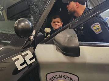 Chelmsford Police Officer Cory D'Entremont shows 6-year-old Tyler Bolger around the inside of a police cruiser during Tyler's visit to the police station with his family. Cops for Kids with Cancer and the Chelmsford Police presented Tyler and his family with $5,500 to help support their ongoing battle with cancer.